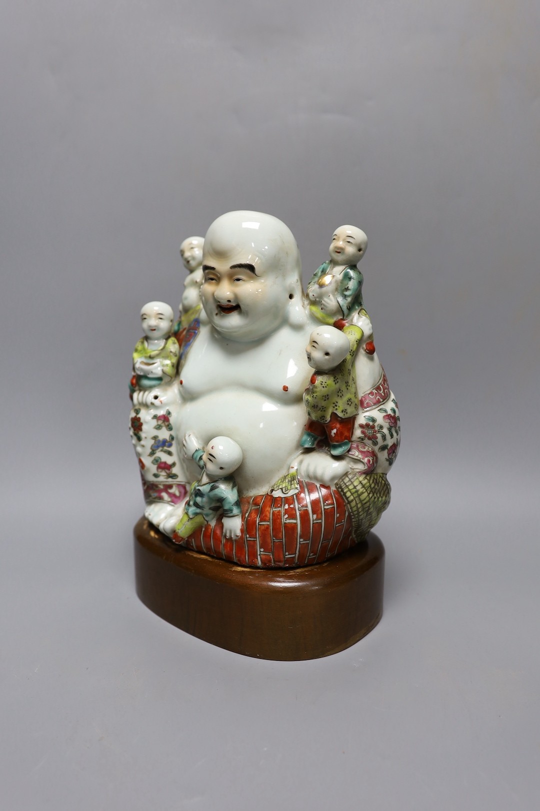 A Chinese enamelled porcelain Budai group, Republic period, on stand 25cm